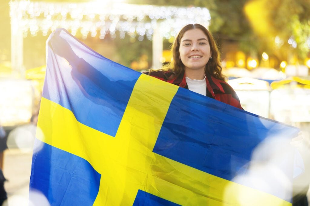 Young woman waving the Swedish flag