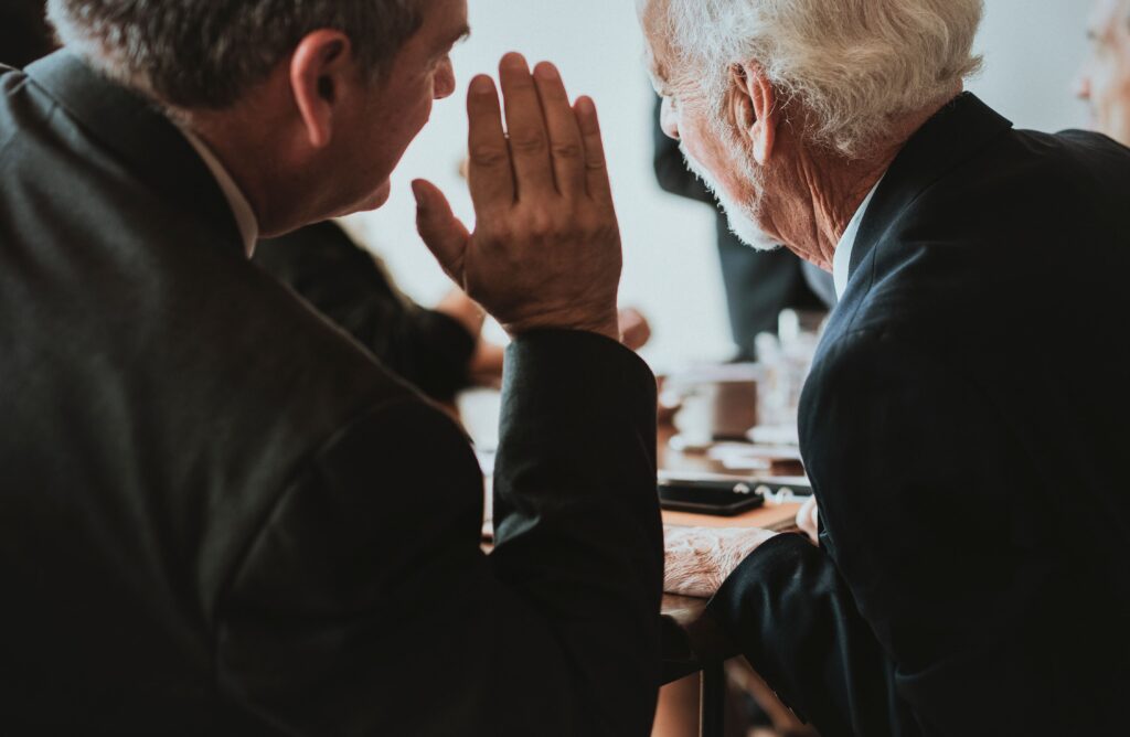 A person interpreting in the ears of another person.