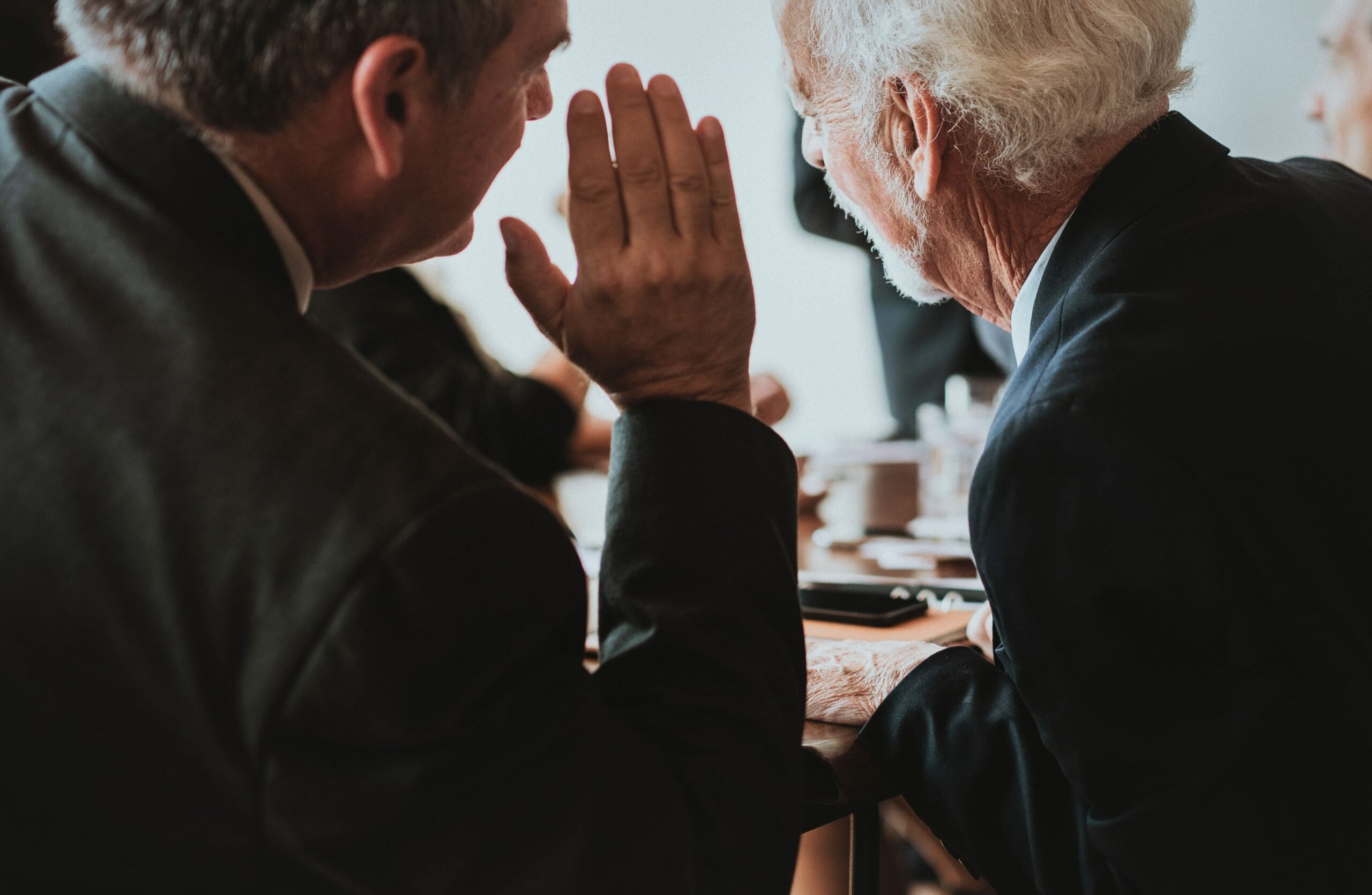 A person interpreting in the ears of another person.