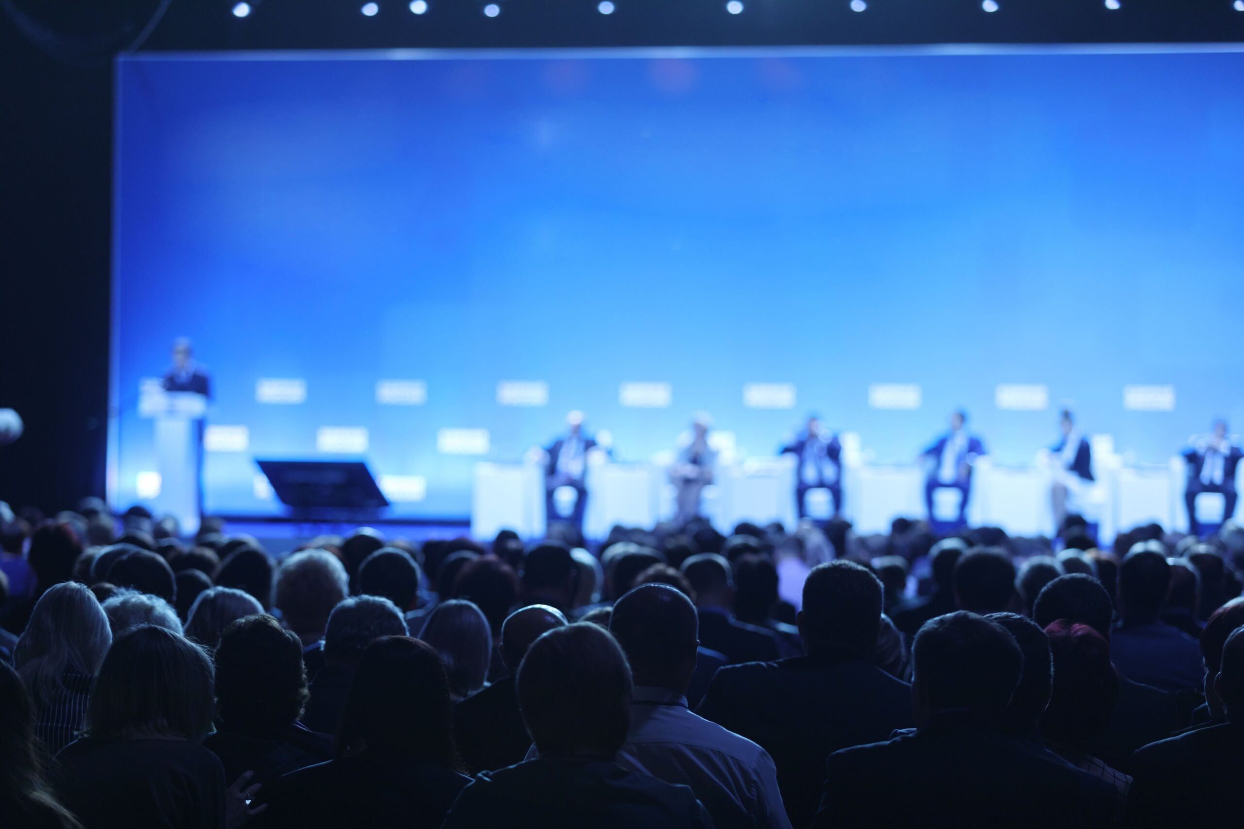 Audience members listening to a panel discussion at a conference.