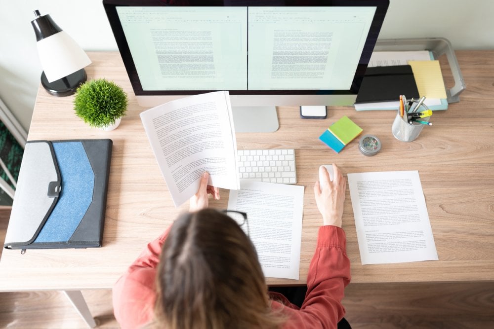 Professional translator reviewing documents at a computer desk