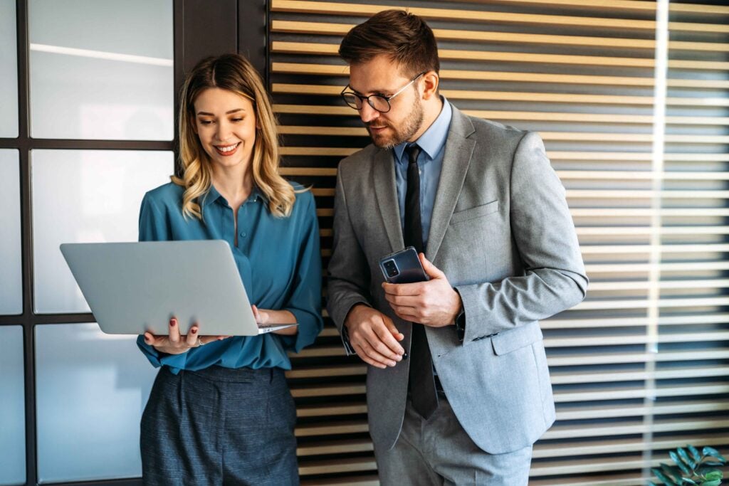 Two business professionals reviewing information together, representing how Japanese cultural norms can influence professional interpretation and cross-cultural communication