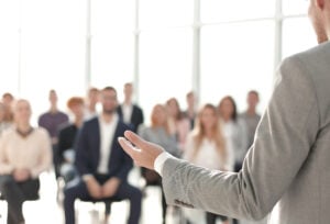 a man speaking in front of the crowd